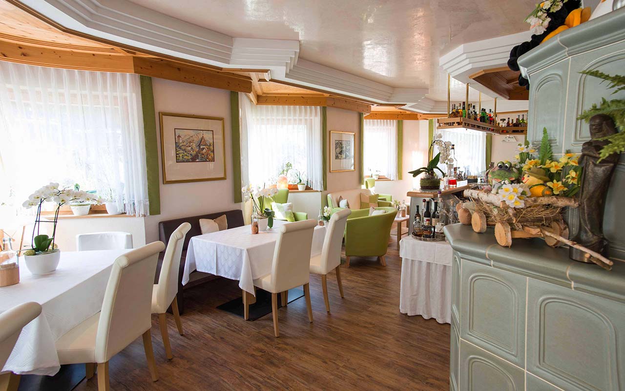 Die Bar im Hotel Fleuralp in Tscherms mit weißer und grüner Einrichtung und Dekorationen