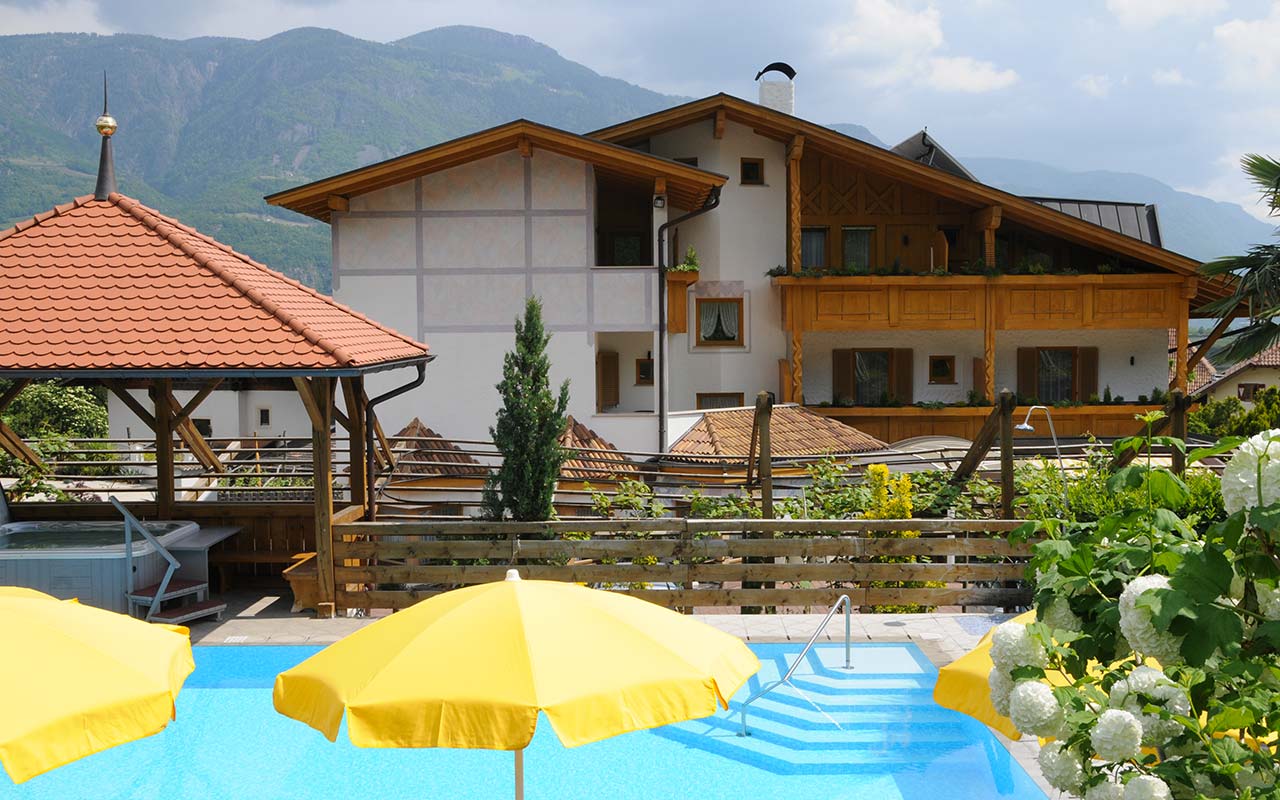 Yellow beach umbrellas and pool in front of Hotel FleurAlp